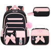 A set of three pink and black cartoon school bags for girls, including a backpack and two small pouches.