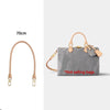 A light gray shoulder bag with a tan leather strap and decorative hardware.