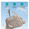 A beige expandable lightweight travel duffle bag is shown against a light blue sky with fluffy white feathers.