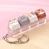 A set of acrylic kawaii cat keycaps and fidget toys displayed on a clear plastic tray with a silver bag charm.