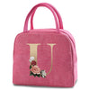 A pink insulated canvas lunch bag featuring a gold letter U and floral embroidery.