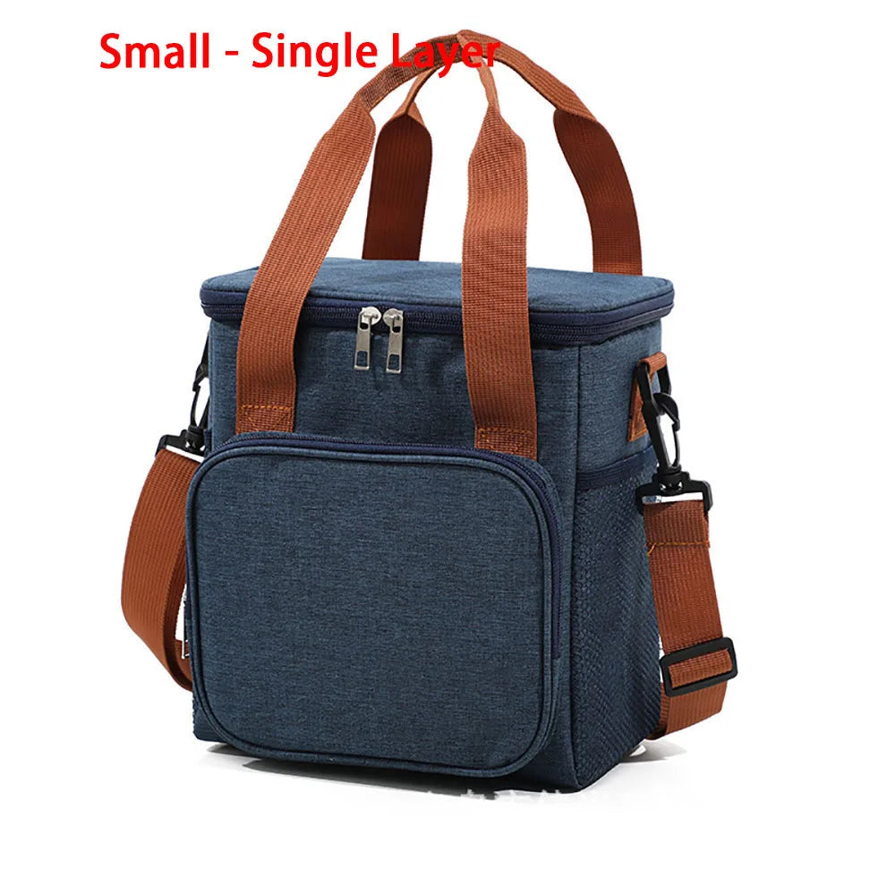 A navy blue insulated lunch bag with brown straps and a separate front pocket.