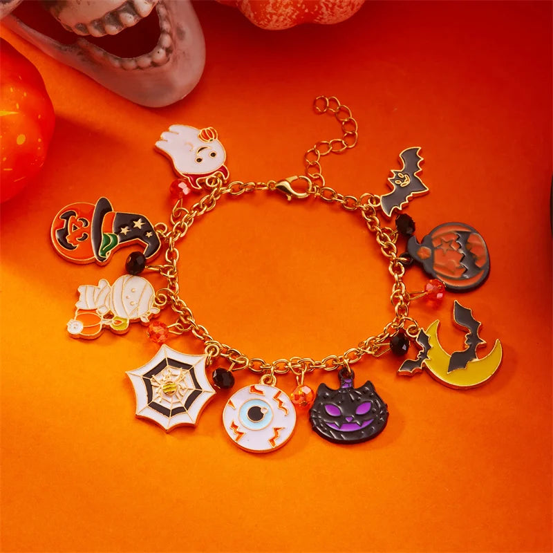A gold charm bracelet featuring Halloween-themed charms like a ghost, pumpkin, and cat on an orange background.