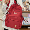 A red lightweight nylon college backpack is shown being carried by a person.
