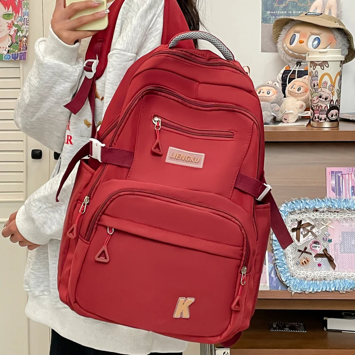 A red lightweight nylon college backpack is shown being carried by a person.