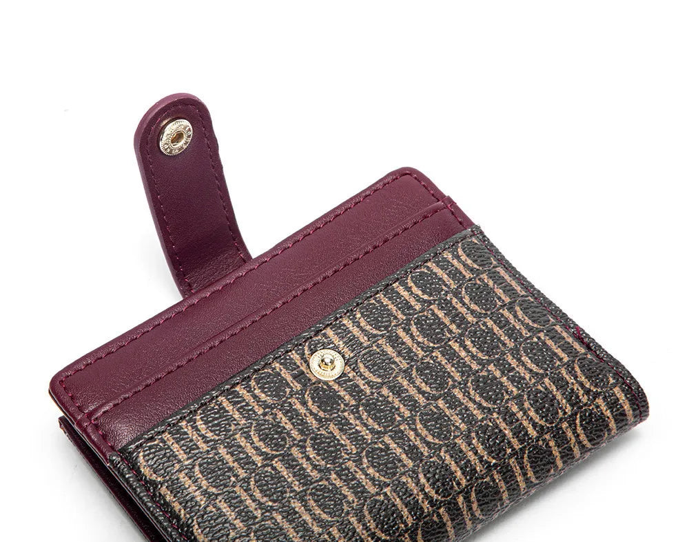 A maroon leather folding wallet with a patterned exterior and a matching sleeve.