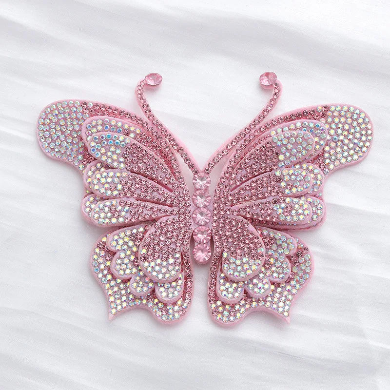 Pink rhinestone butterfly applique sticker with translucent wings on a white background