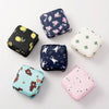 A collection of various cute and decorative compact sanitary pad storage pouches in floral and animal patterns.