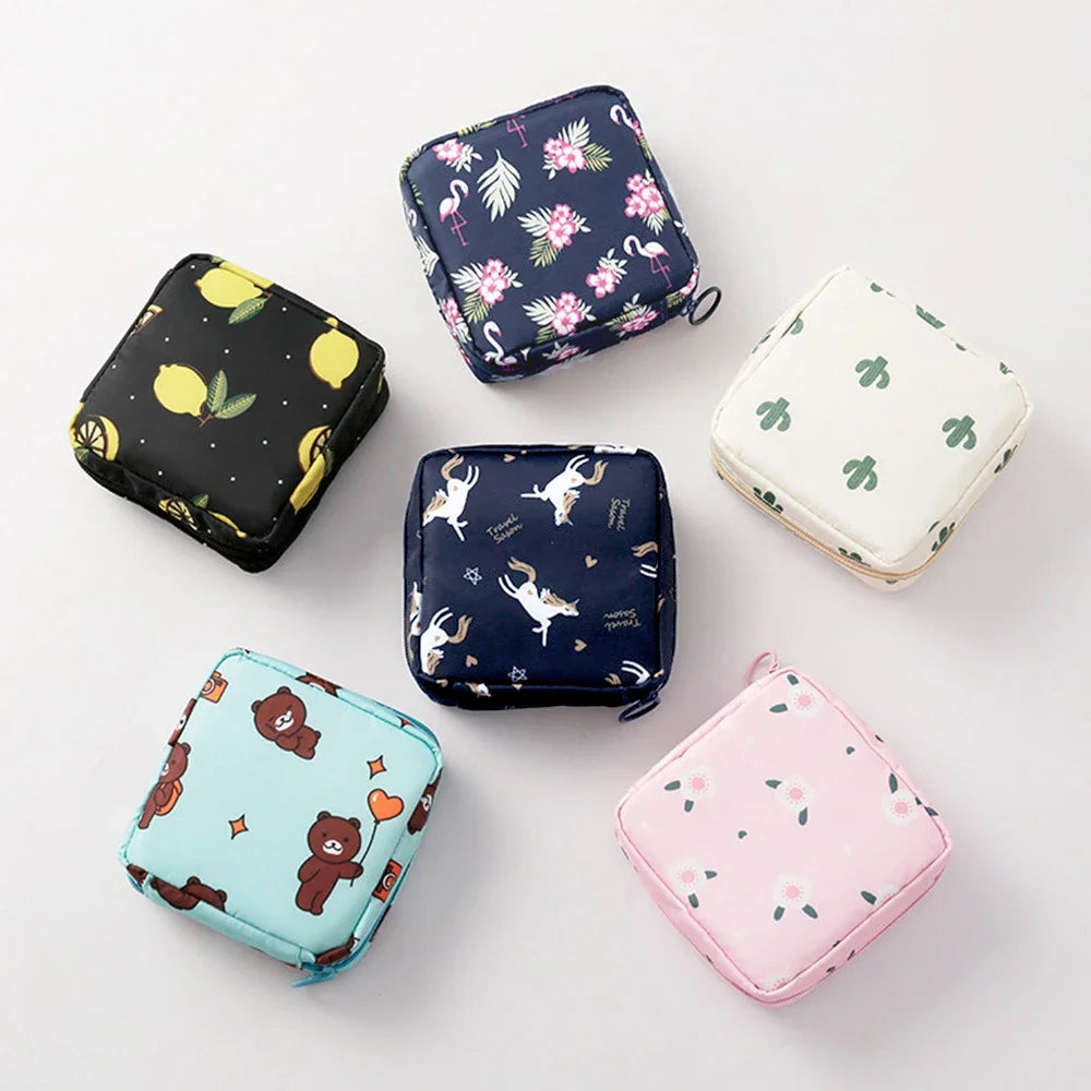 A collection of various cute and decorative compact sanitary pad storage pouches in floral and animal patterns.