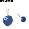 Two blue coin purse keychains featuring a star charm and a fruit shape on a light blue fabric.