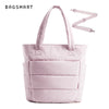 Sac fourre-tout matelassé rose pâle avec une sangle assortie, sur fond blanc.