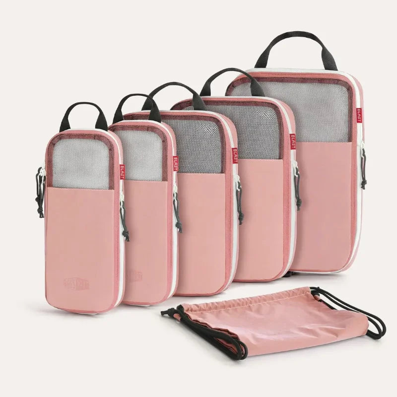 A set of six pink and gray expandable compression packing cubes with black handles.