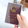 A hand holds a passport with a gold emblem and Chinese text, showing the inside of a card sleeve.