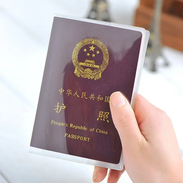 A hand holds a passport with a gold emblem and Chinese text, showing the inside of a card sleeve.