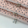 Funda acolchada para laptop floral rosa con tiradores de cremallera plateados.