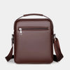 A dark brown vintage PU leather crossbody messenger bag with a zippered compartment and adjustable strap.