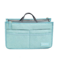 Light blue fabric handbag organizer insert with a gray lining and a dark strap.