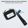 A black sleek everyday wallet with an ID window and a keychain clip attached to a strap.