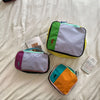 A set of waterproof travel toiletry bags in various colors including green, purple, and orange, resting on a white surface.
