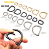 A collection of gold and black D-shape metal spring rings and clasps with various inner widths shown next to a hand.