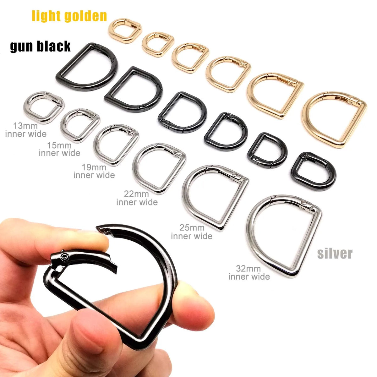 A collection of gold and black D-shape metal spring rings and clasps with various inner widths shown next to a hand.