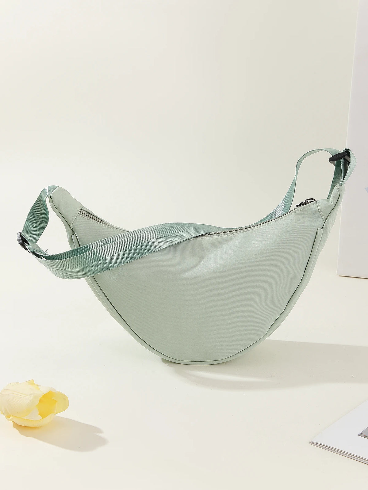 A light mint green women's preppy sling crossbody bag is displayed against a white background.