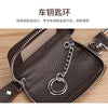A dark brown leather car key case with a transparent window and a silver chain lock is shown on a wooden surface.