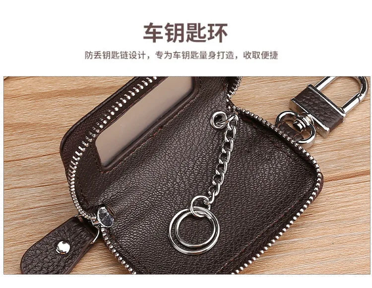 A dark brown leather car key case with a transparent window and a silver chain lock is shown on a wooden surface.