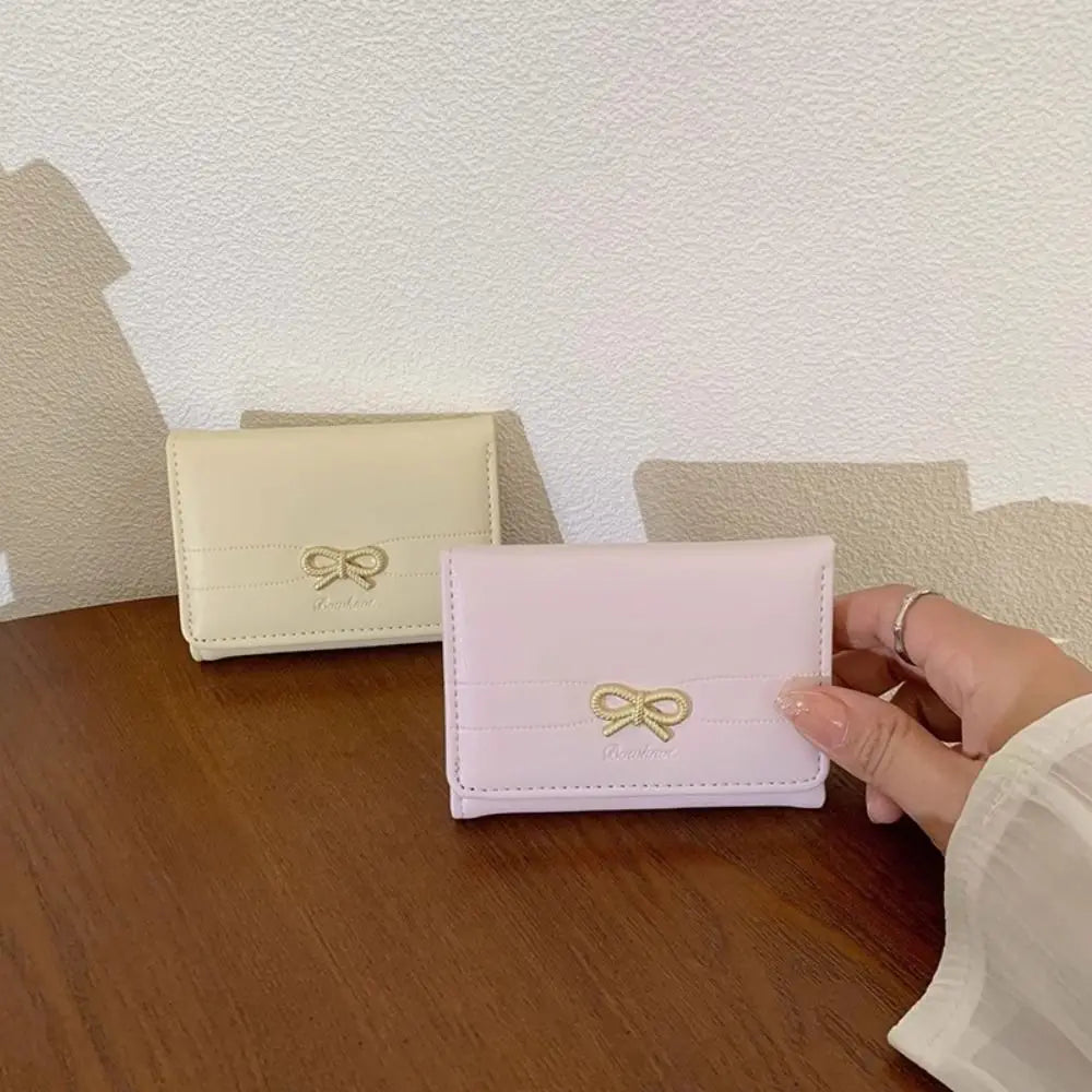 Portefeuille de carte tri-pli en PU rose posé sur une surface en bois.