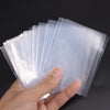 A hand holds a stack of transparent card sleeves or protectors for display.