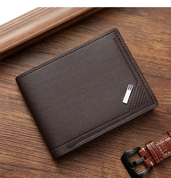 A dark brown slim leather wallet with a money clip is shown resting on a wooden surface.