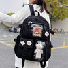 A woman is wearing a black Korean style large capacity backpack with various compartments and cute charms.