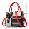 Sac bandoulière en cuir PU à carreaux rouge et noir avec quincaillerie dorée et pompon moelleux.