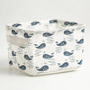 A white storage basket with a lid featuring a repeating pattern of dark blue seals on a light background.