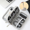 A gray portable digital accessory organizer pouch is open, showing compartments for cables and small electronics.
