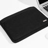 A black multi-pocket laptop sleeve with a handle is shown on a white surface.