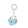 A clear acrylic keychain charm featuring a cute white bear face sitting on a blue fabric background.