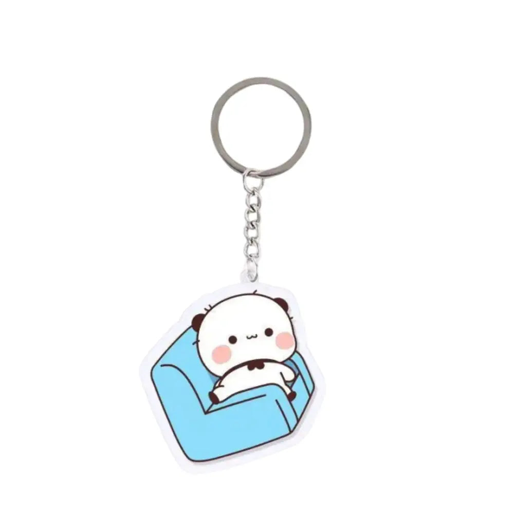 A clear acrylic keychain charm featuring a cute white bear face sitting on a blue fabric background.