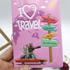 Pink passport cover with I love to travel theme featuring city destination flags like New York, London, Paris, and Amsterdam