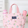Bolsa térmica rosa con estampado floral, mostrada sobre fondo blanco.