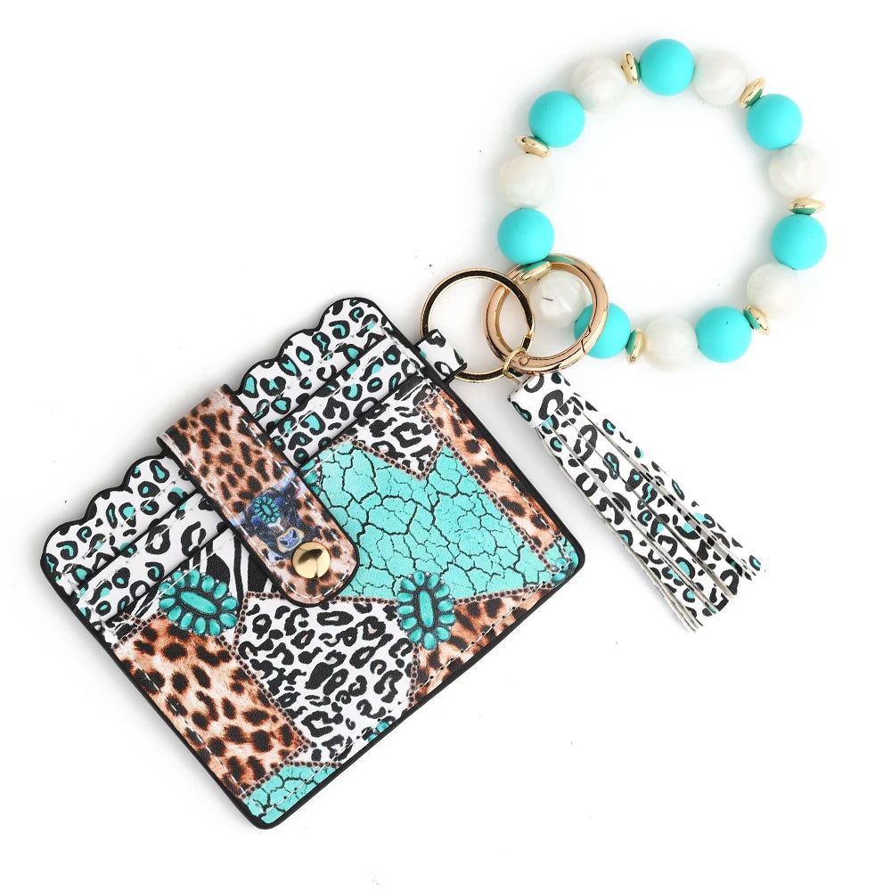 A silicone bead and leather card wallet featuring a leopard print design and white and turquoise beads.