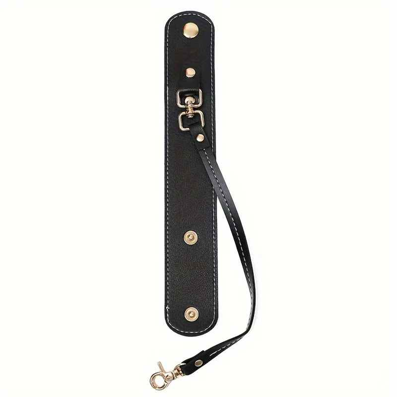 A black vintage leather glove holder strap with brass hardware.