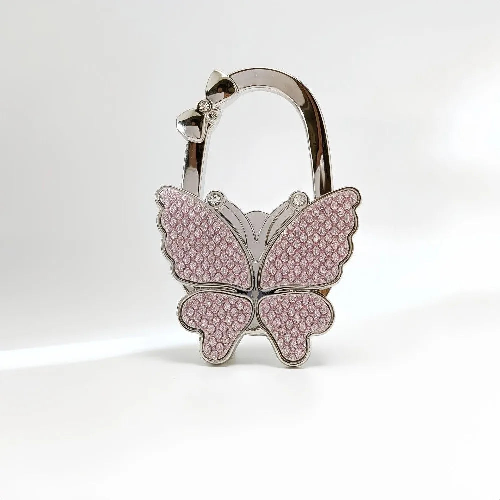 Silver foldable butterfly shaped handbag hook with pink textured detail