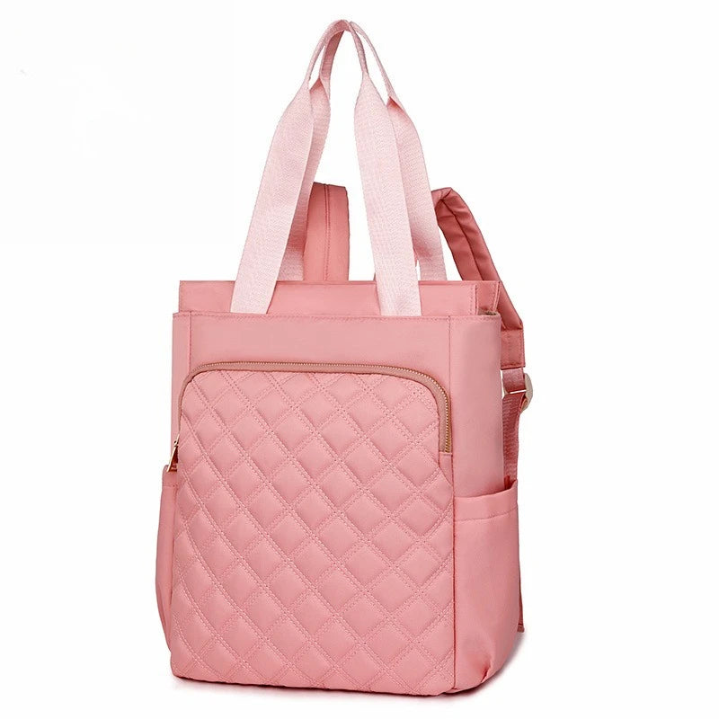 A pink quilted women's backpack tote with pink straps.