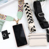 A black phone is shown next to a patterned lanyard and a beige leather wallet.