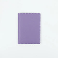A purple PU leather passport holder with stitched edges.
