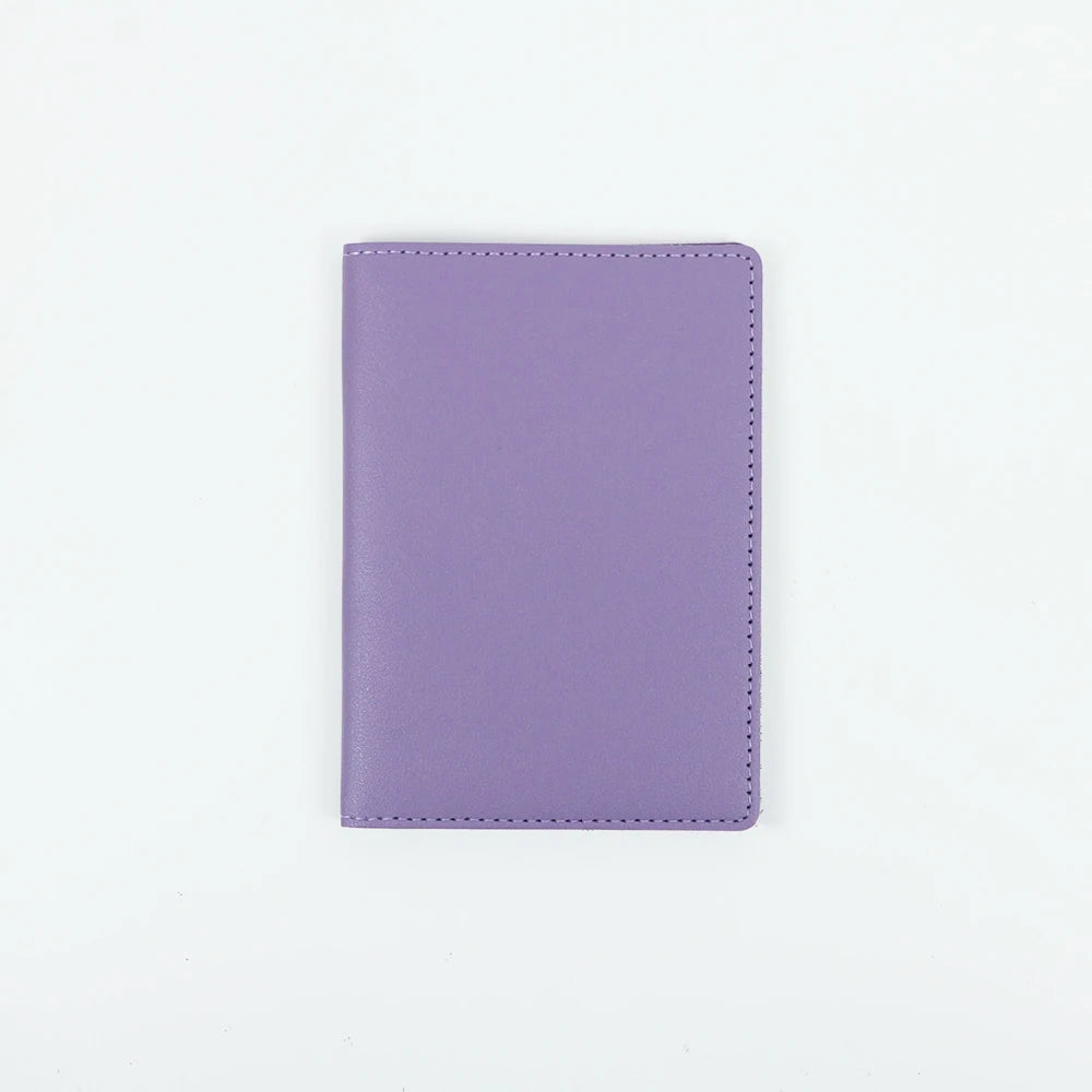 A purple PU leather passport holder with stitched edges.