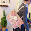 A person is holding a pink Y2K aesthetic transparent shoulder tote bag with floral accents.