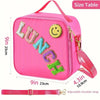 Pink insulated lunch bag with a smiley face patch and adjustable strap