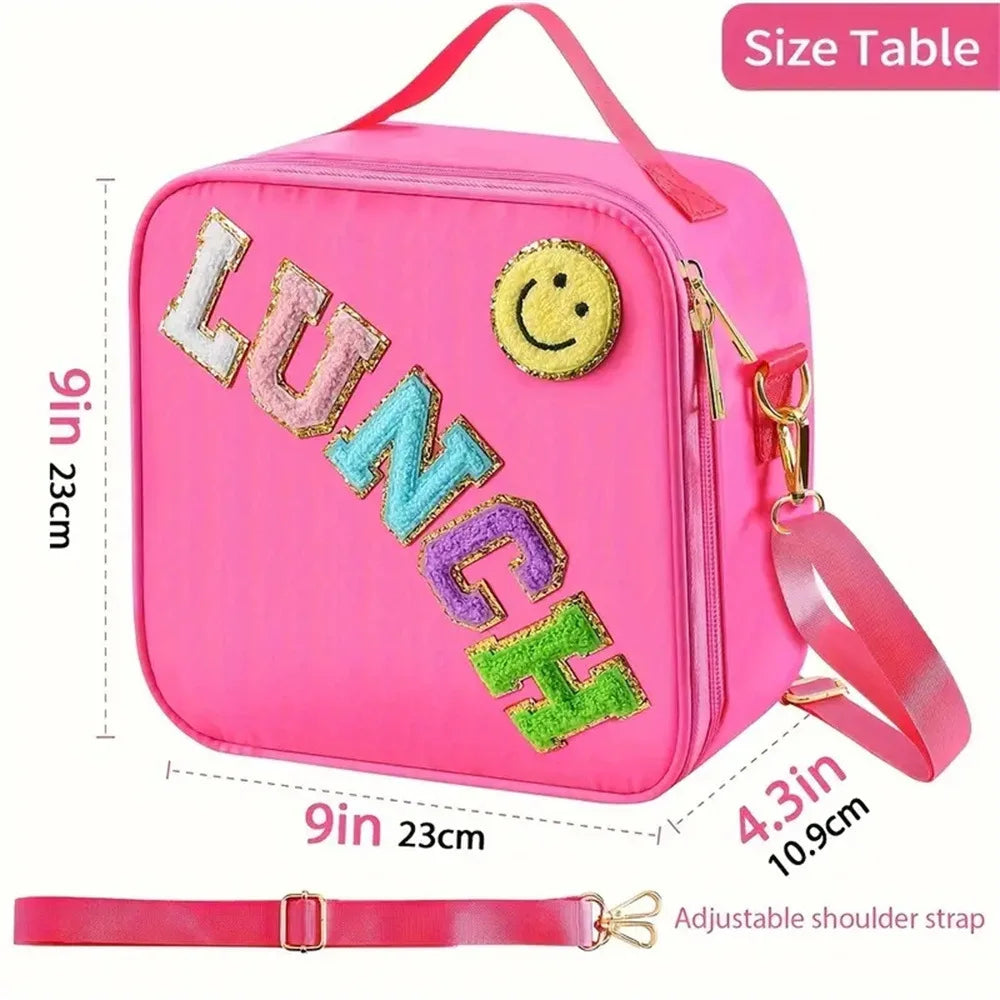 Pink insulated lunch bag with a smiley face patch and adjustable strap